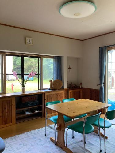 a dining room with a wooden table and chairs at 戸隠の小さな民宿,民泊,ゲストハウス神社神社参拝スキーBreath in Earth in Nagano