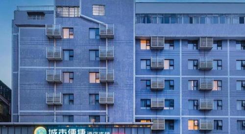 a tall blue building with windows and air conditioning at City Comfort Inn Liuzhou High-speed Railway Station in Liuzhou