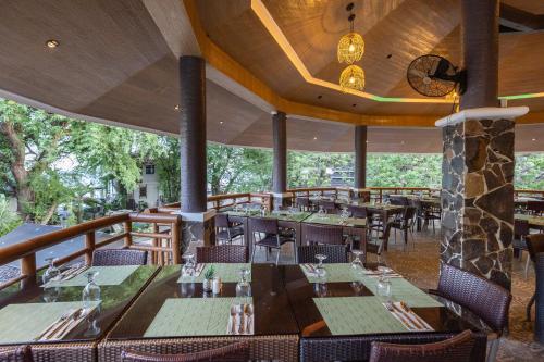 a restaurant with tables and chairs and a balcony at Acuaverde Beach Resort in San Juan