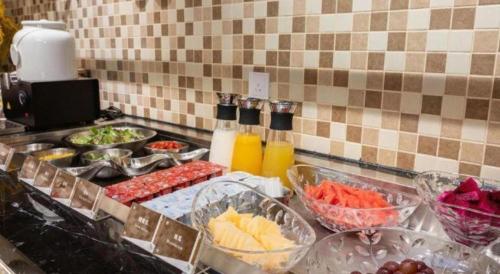 a kitchen counter with many bowls of food on it at Jinjiang Metropolo Haikou East High Speed Railway Station Normal University in Haikou