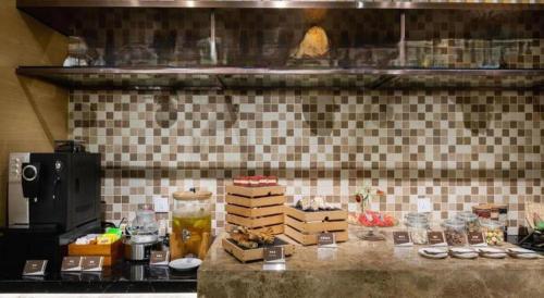 a counter in a kitchen with some food on it at Jinjiang Metropolo Haikou East High Speed Railway Station Normal University in Haikou
