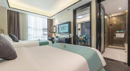 a hotel room with two beds and a television at Xana Hotelle Nanchang Tengwang Pavilion Wanshougong in Nanchang