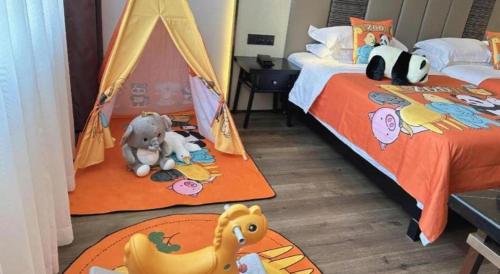 a bedroom with two beds and a toy tent at Jinjiang Metropolo Haikou East High Speed Railway Station Normal University in Haikou