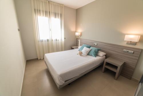 Un dormitorio con una cama con un osito de peluche encima. en Hotel Miguel Sanchez, en Alhaurín de la Torre