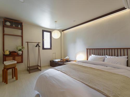 a bedroom with a large white bed and a window at 포켓서울 여의도 in Seoul