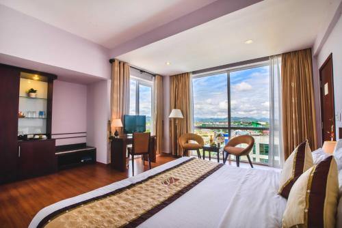 a hotel room with a large bed and a large window at Mondial Hotel Hue in Hue