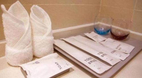 a table with two napkins and a tray with glasses at Lavande Hotels Wuhan Guanggu Yangjiawan Metro Station in Wuhan