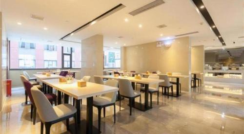 a restaurant with tables and chairs in a room at Lavande Hotels Wuhan Guanggu Yangjiawan Metro Station in Wuhan