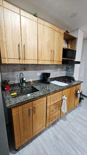a kitchen with wooden cabinets and a counter top at Apartamento centro Marinilla in Marinilla