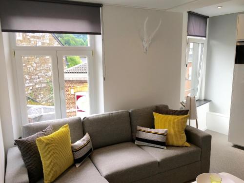 a living room with a couch with yellow pillows at Le Coin Cocoon Bis in Aywaille