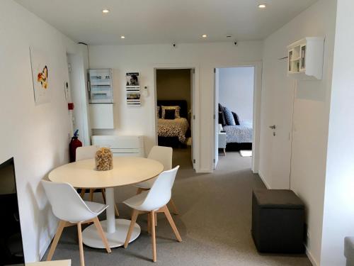 ein Wohnzimmer mit einem Tisch und Stühlen sowie ein Schlafzimmer in der Unterkunft Le Coin Cocoon Bis in Aywaille
