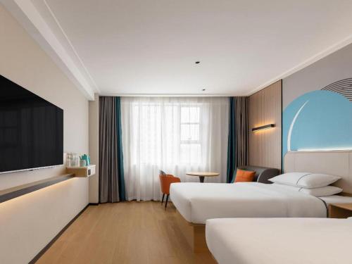 a hotel room with two beds and a tv at City Comfort Inn Shiyan Wudang Mountain in Danjiangkou