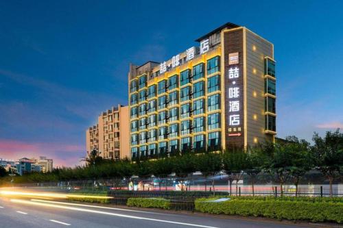 a building on the side of a road near a street at James Joyce Coffetel Guilin Railway Station Xiangbi Mountain Liangjiang Sihu Wharf in Guilin