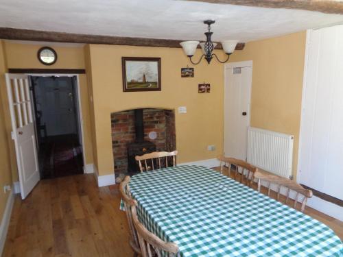 a dining room with a table with a checkered table cloth at Minsmere Cottage in Yoxford
