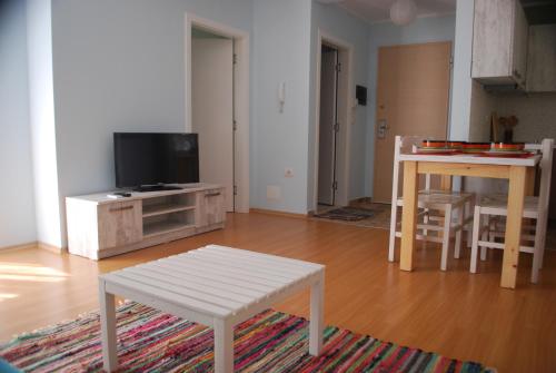 a living room with a table and a tv at Rezidenca Kalter Durres in Golem
