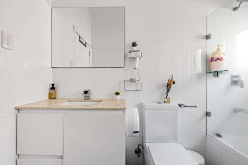 a white bathroom with a toilet and a sink at Freshly Modernized Single Room- Well-Connected Suburb Shared Bathroom in Epping