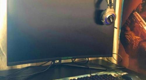 a computer monitor sitting on a desk with a keyboard and headphones at GreenTree Alliance Hotel Shanghai Baoshan District Meilan Lake Yueluo Road in Baoshan