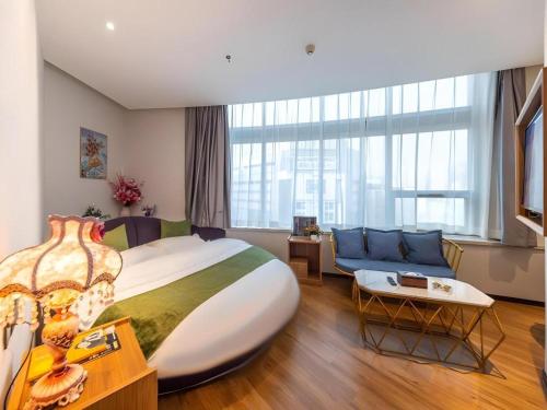 a hotel room with a large bed and a couch at GreenTree Inn Express Lanzhou West Passenger Station Lanzhou Center in Lanzhou