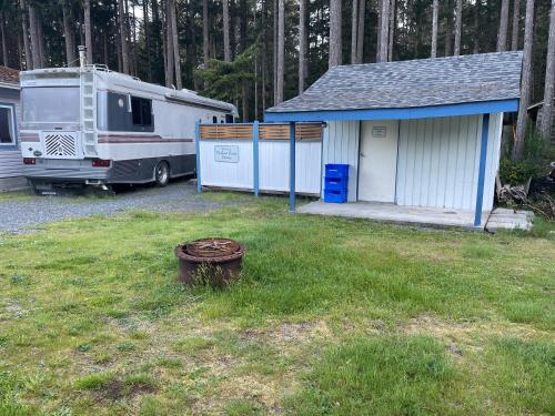 an rv parked in a yard next to a trailer at The Great Escape - Shirley in Sooke