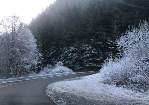 a road with snow on the side of a mountain at The Great Escape - Port Renfrew in Port Renfrew