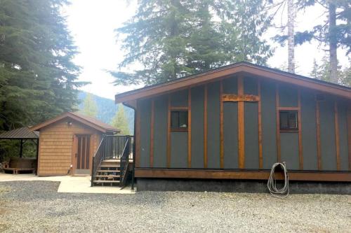 a small cabin with a staircase next to a house at The Great Escape - Port Renfrew in Port Renfrew