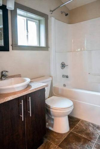 a bathroom with a toilet and a sink and a tub at The Great Escape - Port Renfrew in Port Renfrew