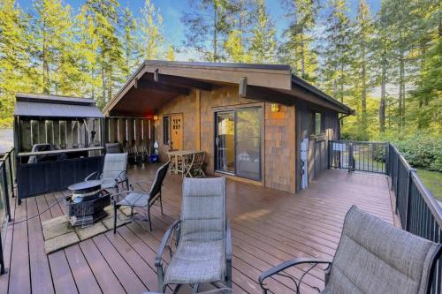 a cabin with chairs and a grill on a deck at The Great Escape - Port Renfrew in Port Renfrew