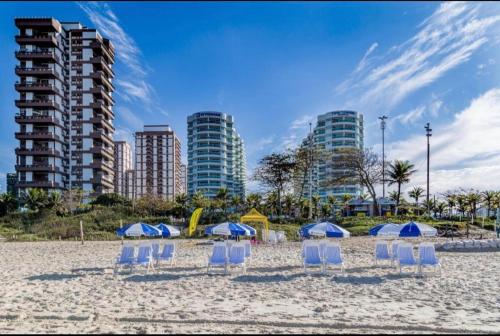 a group of chairs and umbrellas on a beach at VISTA ESPETACULAR - TWIN TOWERS - Barra da Tijuca in Rio de Janeiro