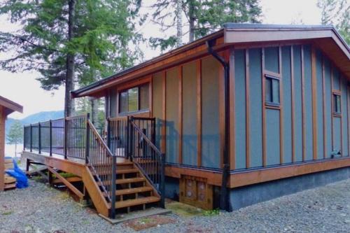 a tiny house with a staircase and a porch at The Great Escape - Port Renfrew in Port Renfrew