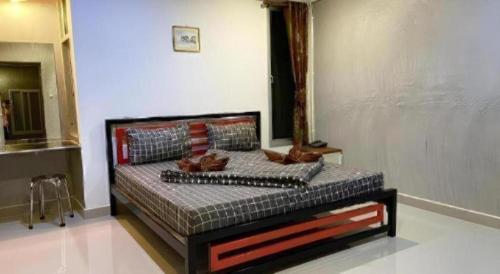 a bedroom with a bed with shoes on it at Kidthuengpark in Si Racha