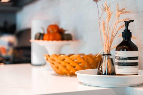 a bottle of soap on a counter with a basket of fruit at Cozy 2BR Apt with Parking, Steps to Brown and RISD in Providence
