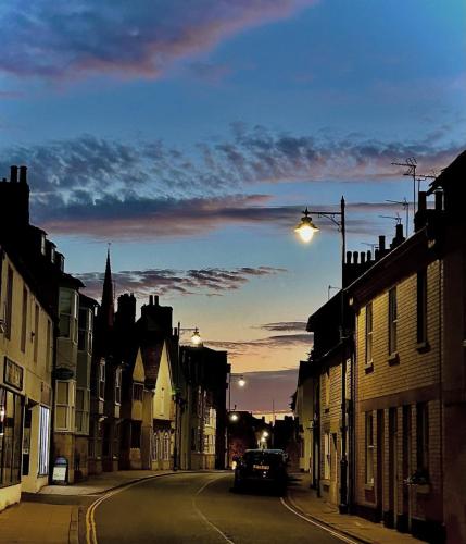a city street with a car driving down a street at 2 bedroom cottage in Stamford in Lincolnshire