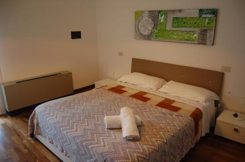 ein Schlafzimmer mit einem Bett mit zwei Handtüchern darauf in der Unterkunft Appartamento Elegance in Lignano Sabbiadoro