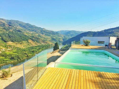 uma piscina com vista para um rio em Imaginário D'El Rei - Guest House em Mesão Frio