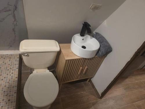 a bathroom with a white toilet and a sink at Cozy A-Frame Beach Cabin Sihu-A Casa in Las Piedras