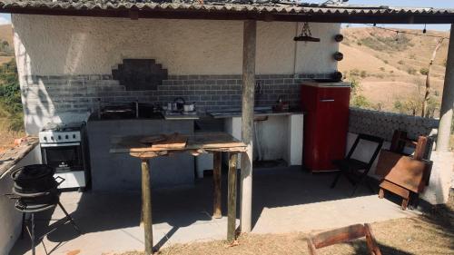 Una cocina al aire libre con encimera y estufa. en Espaço fazendinha por do Sol da piscina, en Paty do Alferes