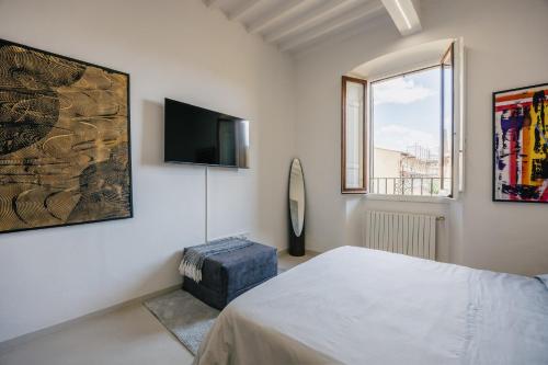 a bedroom with a bed and a tv on the wall at Palace d'Art - Centro Storico di Arezzo in Arezzo