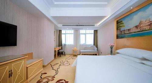 Ένα ή περισσότερα κρεβάτια σε δωμάτιο στο Vienna Hotel Hubei Xiangyang Tang City Gulou