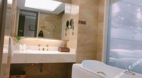 a bathroom with a sink and a mirror at Venus Royal Hotel Nanning East High-Speed Railway Station in Nanning