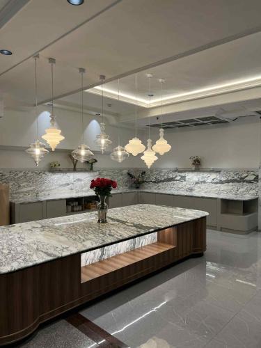 a large kitchen with a counter with flowers on it at Elizabeth Hotel in Bangkok