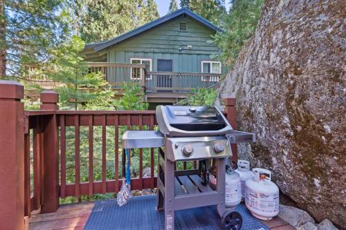 a grill on a deck with a house in the background at Lewis Creek cabin near Yosemite king beds in Oakhurst