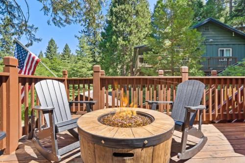 two chairs and a fire pit on a deck at Lewis Creek cabin near Yosemite king beds in Oakhurst
