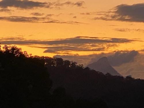 a sunset with a mountain in the background at Eagles Rest -4WD AWD access -a private retreat for two- in Upper Burringbar