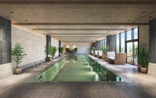 an indoor pool in a building with plants at 1 Hotel Tokyo in Tokyo
