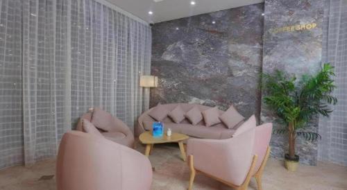 a living room with two chairs and a couch and a table at ALAZMI HOTEL in Dubai