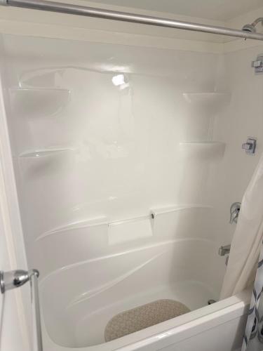 a white bath tub in a bathroom with a shower curtain at LuxSpaces Ventures in London