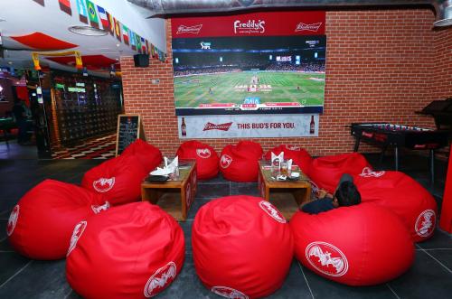a room with red bean bag chairs and a tv at Dubai Grand Hotel by Fortune, Dubai Airport in Dubai