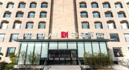 a building with a sign on the front of it at Borrman Hotel Changzhi Medical College Wulong Campus High-speed Railway South Station in Changzhi