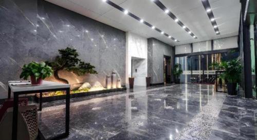 a large hallway with a plant on the wall at Borrman Hotel Changzhi Medical College Wulong Campus High-speed Railway South Station in Changzhi