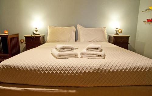 a bedroom with a bed with towels on it at Archontiko Hatzipanayioti in Leonidion